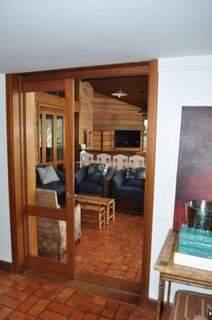 Da sala, porta de madeira divide interior com a churrasqueira. (Foto: Marcelo Calazans)