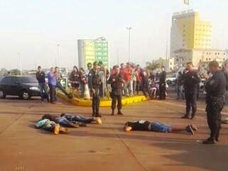 Os quatro assaltantes deitados no chão após serem cercados pela polícia (Foto: Léo Veras/Porã News)
