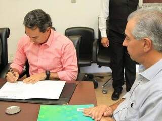 Marquinhos Trad (à direita) assinando contrato; Reinaldo Azambuja ao lado (Foto: Marina Pacheco)