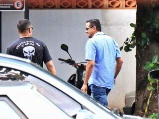 Policial militar (de camisa listrada) chegando na delegacia (Foto: Henrique Kawaminami) 