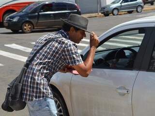 Com humildade, ele se apresenta a cada motorista, conta sua história e espera receber qualquer doação em troca. (foto: Thaís Pimenta)