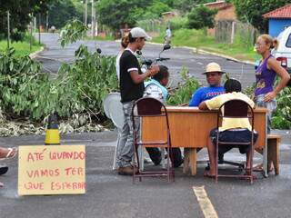 Moradores colocaram mesa na rua para bloquear trânsito. Presidente do bairro, no centro, diz estar em greve de fome. (Foto: João Garrigó)