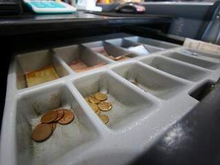 Espaços para moedas em caixa de supermercado estão quase vazios (Foto: André Bittar)