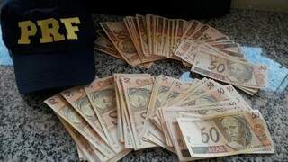 Dinheiro falso estava escondido em encosto da poltrona de ônibus. (Foto: PRF/ Divulgação)