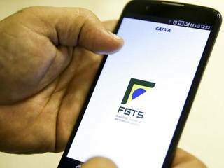 Aplicativo do FGTS sendo usado em aparelho celular (Foto: Marcelo Camargo/Agência Brasil)
