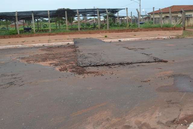 Chuva alaga posto de sa&uacute;de, abre crateras e leva parte do asfalto