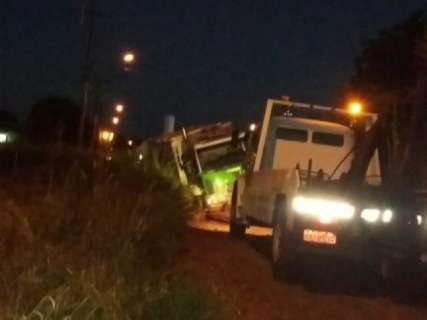 Carregado, caminhão de lixo quase tomba e fica preso em buraco de rua 