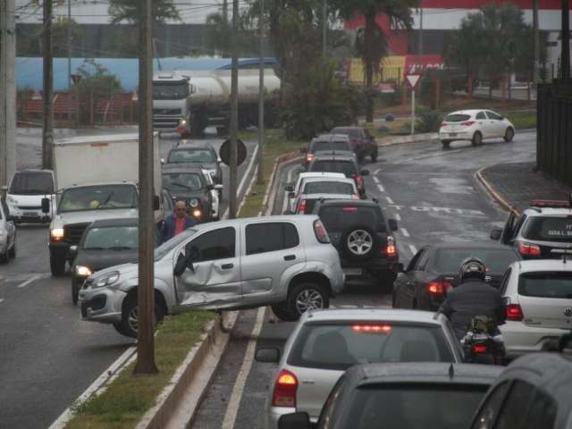 Ap&oacute;s &lsquo;fechada&rsquo; de caminh&atilde;o, carro fica preso em canteiro na avenida Zahran