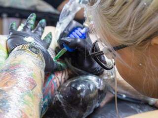 Paty tatuando em seu estúdio, em Campo Grande. (Foto: Arquivo pessoal).