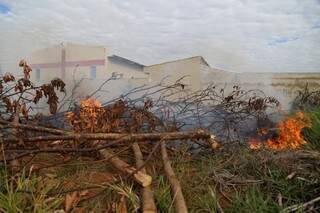Terreno ao lado da casa de Cíntia pegando fogo. (Foto: Fernando Antunes)