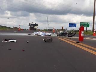 Corpo de motociclista ainda não identificado coberto após acidente (Foto: Geisy Garnes)