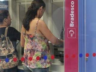 Mulher em caixa eletrônico do Bradesco em Campo Grande (Foto: Arquivo)