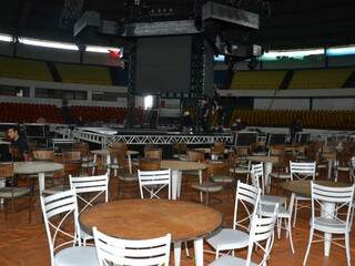 Mesas ficam ao lado do palco. 