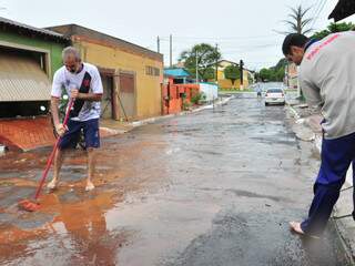 Moradores limpam a sujeira na rua. (Foto: João Garrigó)