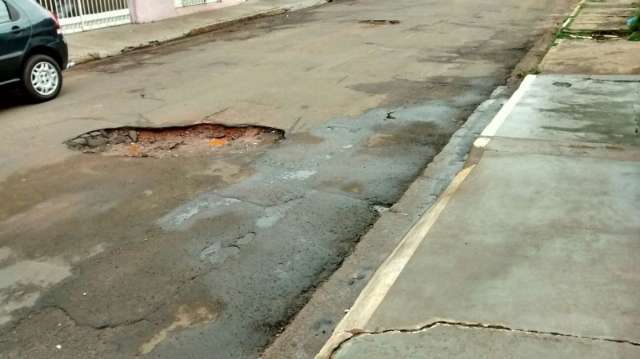 Morador sofre com cratera enquanto tapa-buraco passa em rua pr&oacute;xima
