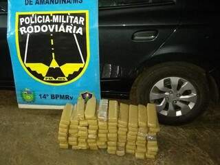 Tabletes de maconha encontrados sob a lataria do veículo. (Foto: Divulgação/PMR) 