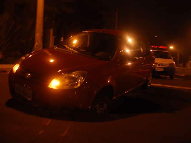 Carro "atola" em buraco na rotat&oacute;ria perto da C&acirc;mara de Vereadores