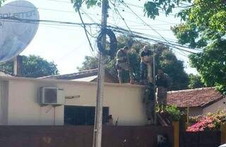Policiais paraguaios recolhem granadas que não explodiram, no telhado de rádio (Foto: ABC Color)