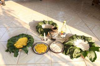 As oferendas sobre as folhas de mamonas e nos pratos de barro, ao lado da vela branca, do jarro com água e da cachaça , (Foto: Paulo Francis)
