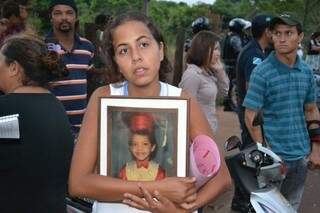 Mulher de Jefferson de Souza Pereira leva quadro com a foto da vítima do acidente fatal (Foto: Pedro Peralta)