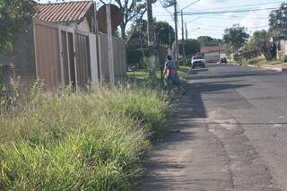 Moradores têm que andar no meio da rua para desviar do mato (Foto: Marcos Ermínio)
