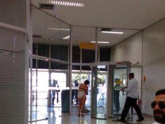 Mulher tira a roupa para passar em porta giratória do Banco do Brasil