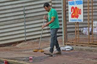 Sem os serviços de varrição, lojistas procuram manter a limpeza nas calçadas do Centro. (Foto:Marcos Ermínio)