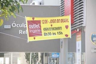 Cartaz informa o horário de atendimento de loja no dia do jogo de estréia do Brasil. (Foto: Marcos Ermínio) 
