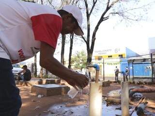 Homem aproveita torneira no Centro da Capital para se refrescar (Foto: Kísie Ainoã)