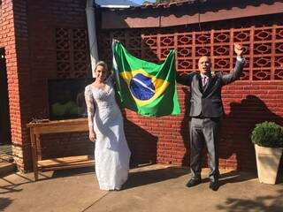 Rebeca e Bruno seguram a bandeira do Brasil durante partida, acompanhada pelos convidados na festa, após união religiosa. (Foto: João Vermelho/Arquivo Pessoal)