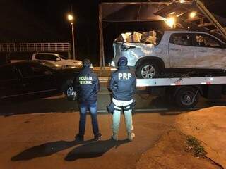 Policiais observam Fiat Toro lotada de maconha, rebocada após capotar na BR-163 (Foto: Divulgação)