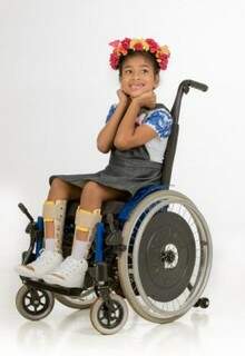 Jardineira infantil foi pensada para vestir a criança sem tirá-la da cadeira de rodas.  (Foto: Antônio Arguello)