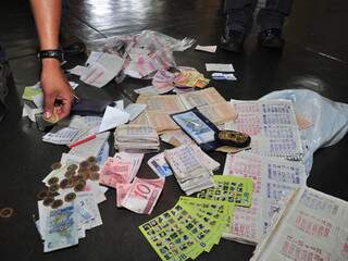 Talonários do jogo do bicho e dinheiro apreendido durante a ação ontem. (Foto: João Garrigó)