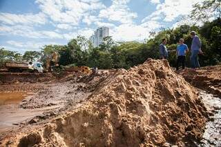 Areia retirada do lago menor; nos fundos da foto e entre duas pessoas, o prefeito Marquinhos Trad recebe explicações sobre a obra (Foto: Diogo Gonçalves)