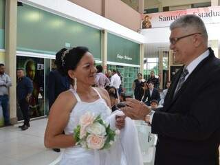 Sandoval Pereira mostrando as alianças para a noiva, Lucélia da Silva (Foto: Alana Portela )