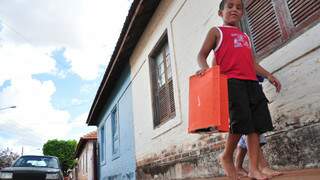 Descalços, meninos brincam em Vila que tem 10 vezes a mais do que a idade deles. (Foto: João Garrigó)