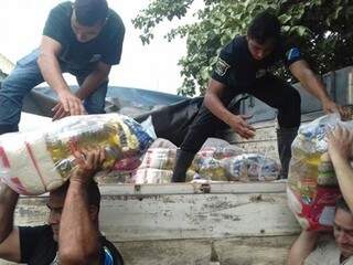 Equipes descarregam cestas básicas que foram distribuídas (Foto: Divulgação)