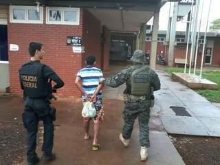 Um dos presos em operação desta quarta-feira em Caarapó é conduzido por policiais federais (Foto: Osvaldo Duarte/Dourados News)