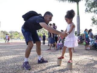 O professor de educação física, Alcimar ensinando a filha andar na perna de lata (Foto: Kisie Ainoã)