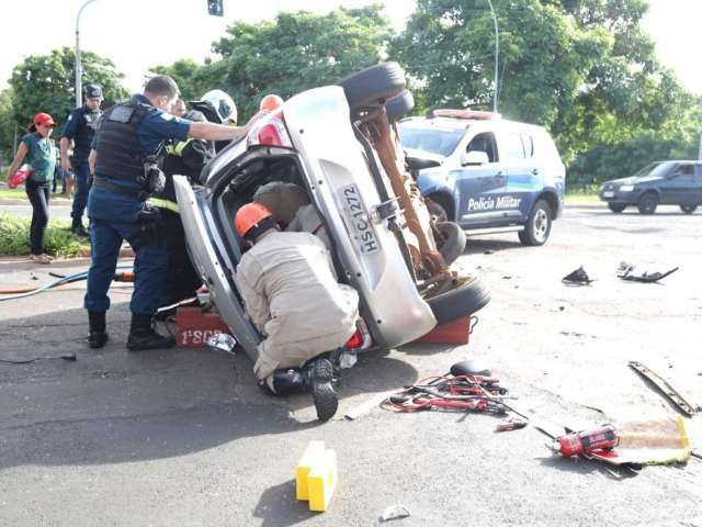Carro fura sem&aacute;foro em avenida, bate em viatura da Pol&iacute;cia Militar e tomba