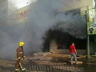 Bombeiro observa fumaça sair de prédio de centro comercial no Paraguai (Foto: Amambay Notícias)