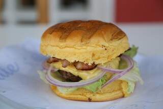 Com 180 gramas de hambúrguer de ponta de costela no pão brioche, cebola roxa, alface americana, queijo prato e bacon, por apenas R$ 18,00. (Foto: Paulo Francis)