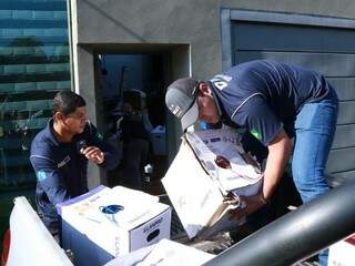 Agentes colocam caixas de aparelhos eletrônicos na carroceria de caminhonete da Receita Federal (Foto: Henrique Kawaminami)