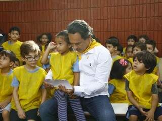 Prefeito Marquinhos Trad com criança de Ceinf mostrando desenho que ilustra campanha Maio Amarelo (Foto: Saul Schramm)