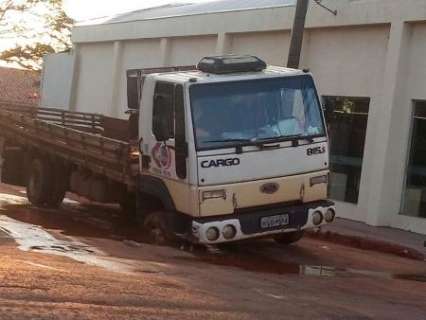 Mesmo descarregado, caminh&atilde;o fica &#039;atolado&#039; ao cair em cratera no Centro