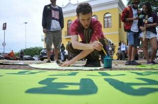 Jovens preparam os cartazes e faixas na concentração da marcha da maconha (Foto: Alcides Neto)