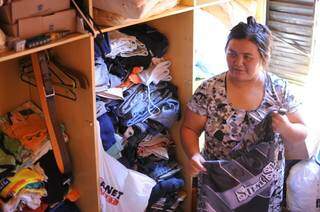 Dona Diana mostra o quarto lotado de caixas de roupas. (Foto:Alcides Neto)