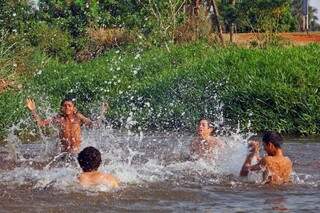Com calor de 36ºC nesta tarde em Campo Grande, meninos aproveitam para se refrescar nas águas do Imbirussú. (Foto: Marcos Ermínio)