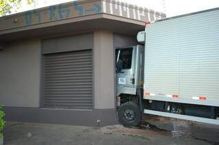 Com o impacto da batida, o caminhão derrubou o muro do depósito e a cabine do veículo ficou totalmente dentro do imóvel (Foto: Simão Nogueira)