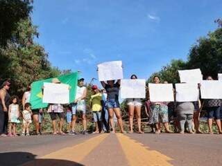 Manifestantes segurando cartazes de protesto na BR-262 nesta manhã (Foto: Henrique Kawaminami)
